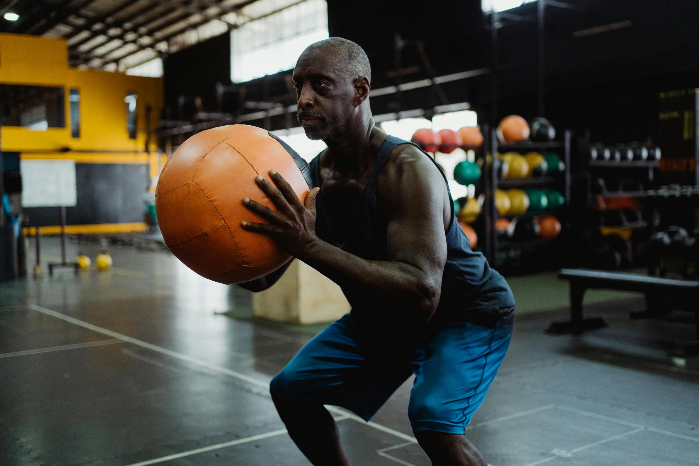 a man is practicing medicine balls on a gym floor