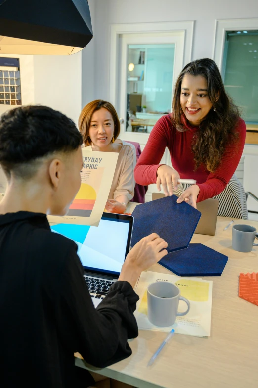 a woman showing her design process with other people in the background