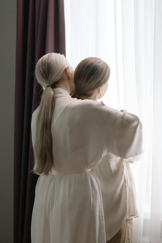 a couple of people standing in front of a window