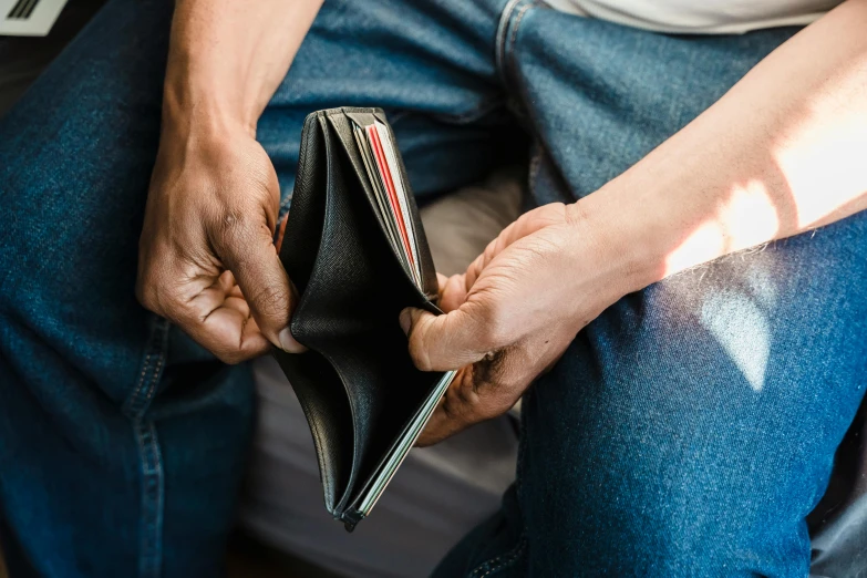 a man sits with his wallet in his hands