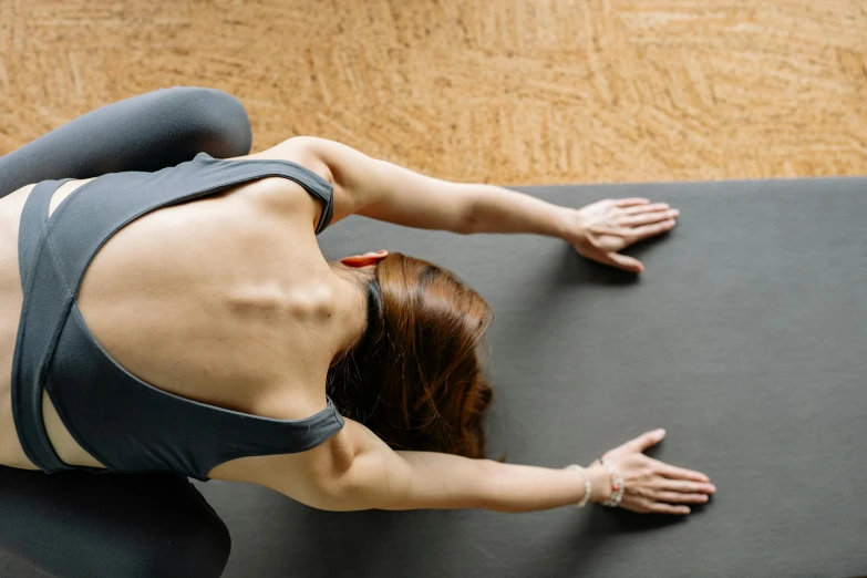 a woman is doing stretching exercises while looking down