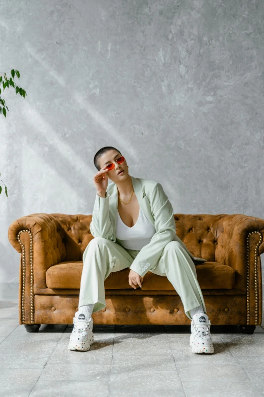 a woman sitting on an old couch and holding a cigarette