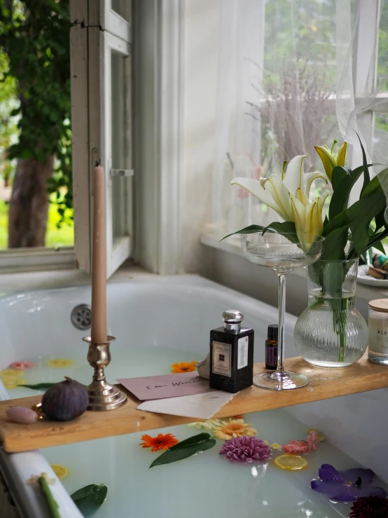 a vase of flowers next to an orchid in the bathtub