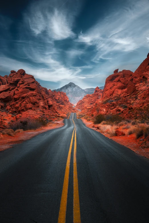 there are several hills in the distance and the road is wide