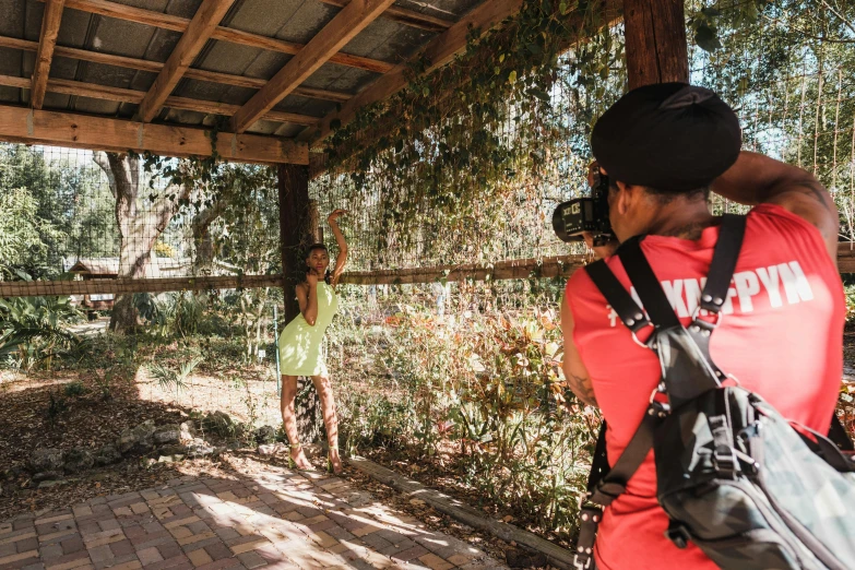 a man takes pictures of a young child in a park