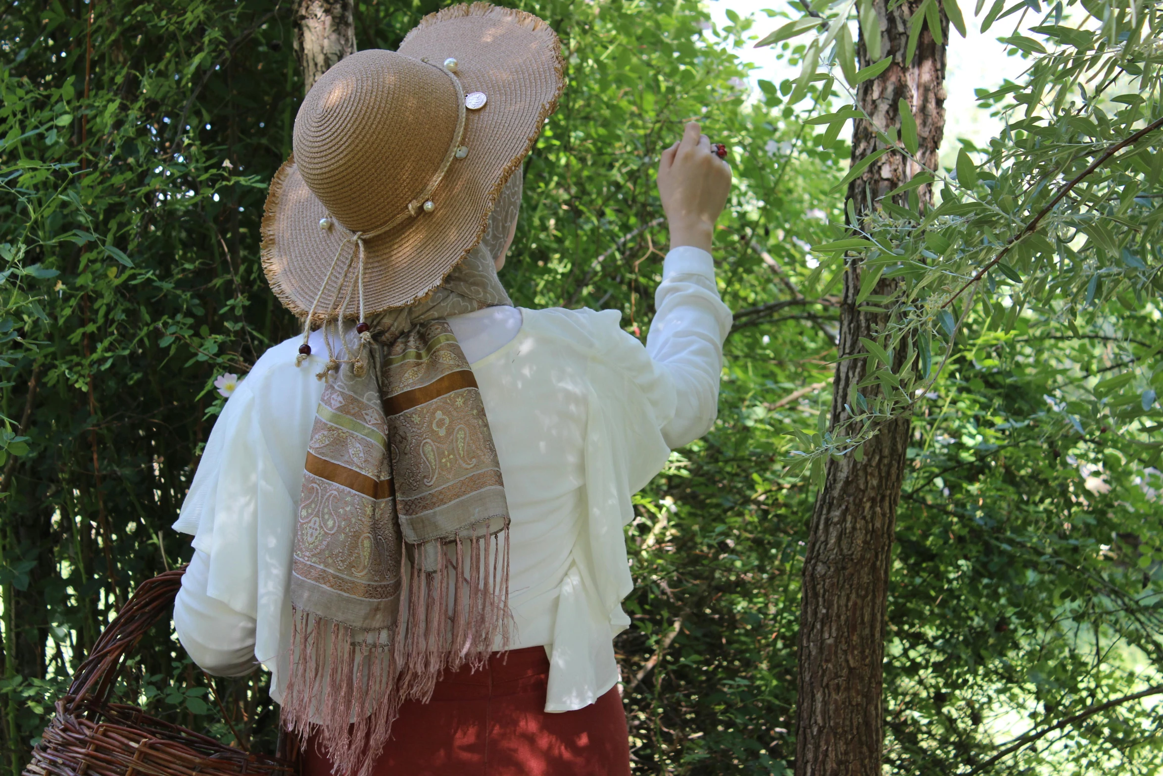 a woman in a straw hat with her hand up