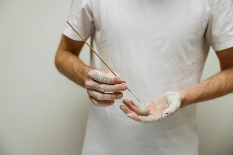 a person holding a tooth brush and cleaning it with a cloth