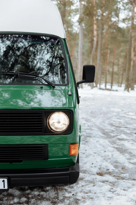 a small green van sitting on top of snow covered ground