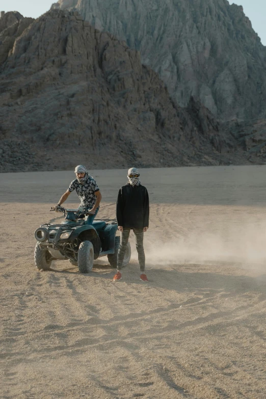 a couple of people on four wheelers in the dirt