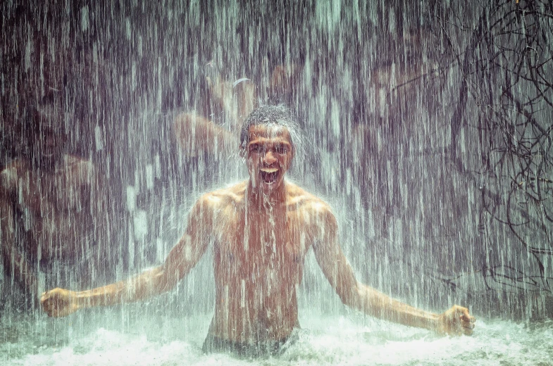 a man standing in the rain holding his hands out