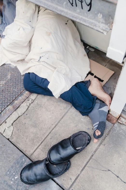 the young man lies on the ground under a bench