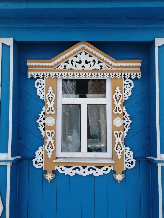 a window on the side of a building with a blue facade