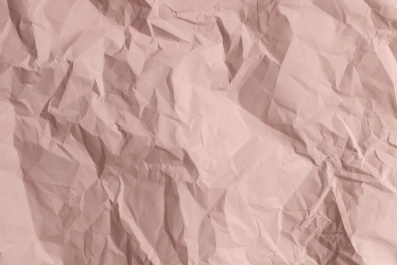 a very wrinkled up piece of paper on a pink background