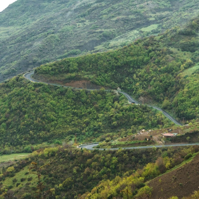 winding mountains, dirt roads and houses in the distance