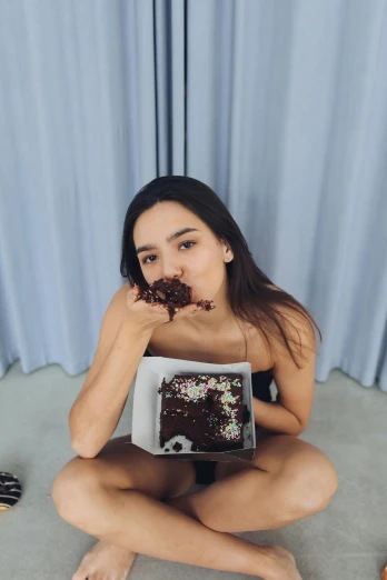 a woman sitting down while eating a piece of cake