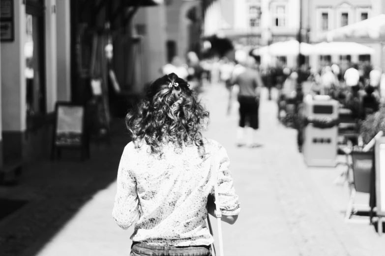woman walking down a sidewalk in a foreign town