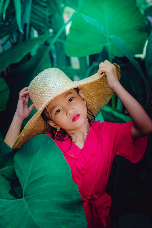 a young child is wearing a hat with a big bow around her head