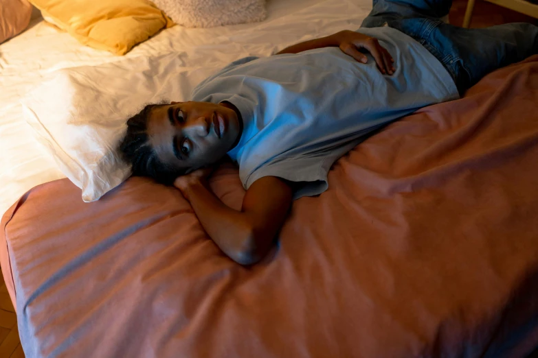 a young child lays on a bed with pillows