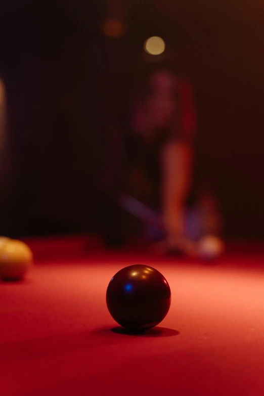 pool balls on red felt with blurry figure in background