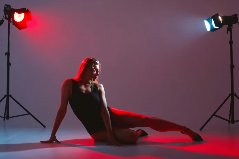 the woman is sitting on the floor in front of several pography lighting