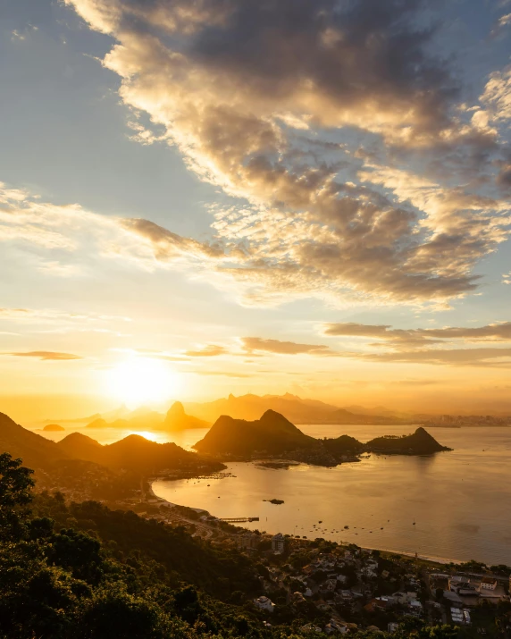 the sun setting over a hill overlooking some water