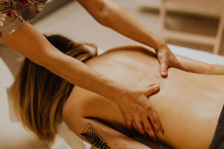 a woman is getting a back massage with a man