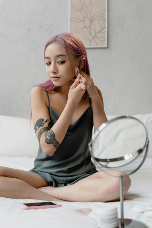 a woman is sitting on the bed with her hair in ponytail