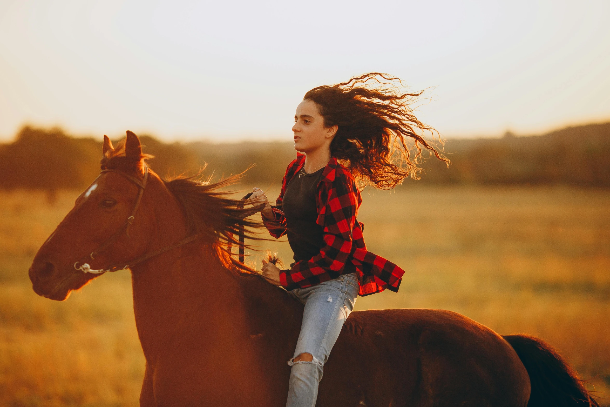 a young woman is riding a horse through the grass