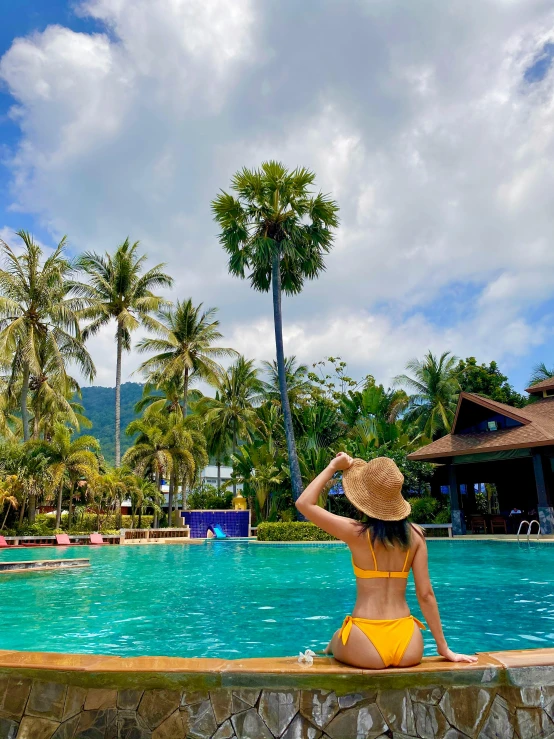 a girl in a bikini at the edge of a pool