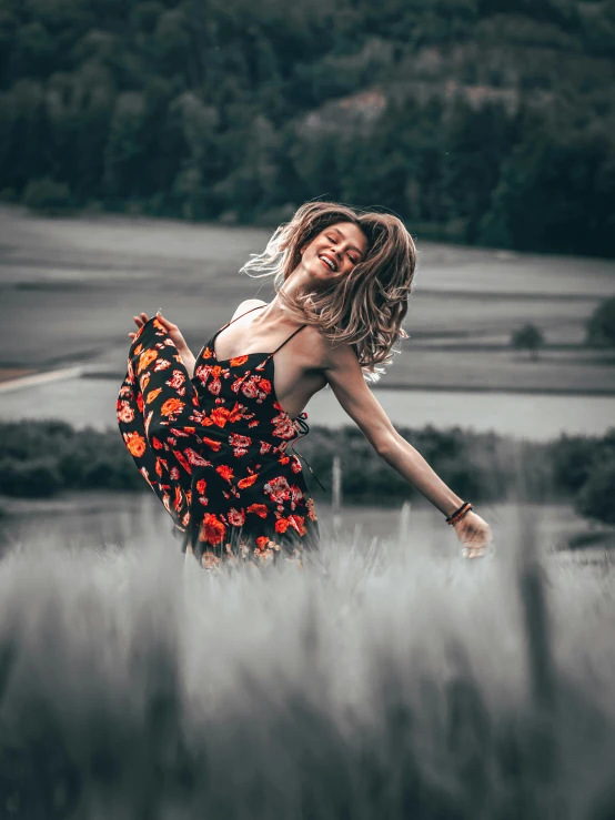 the young woman poses in a field of tall grass