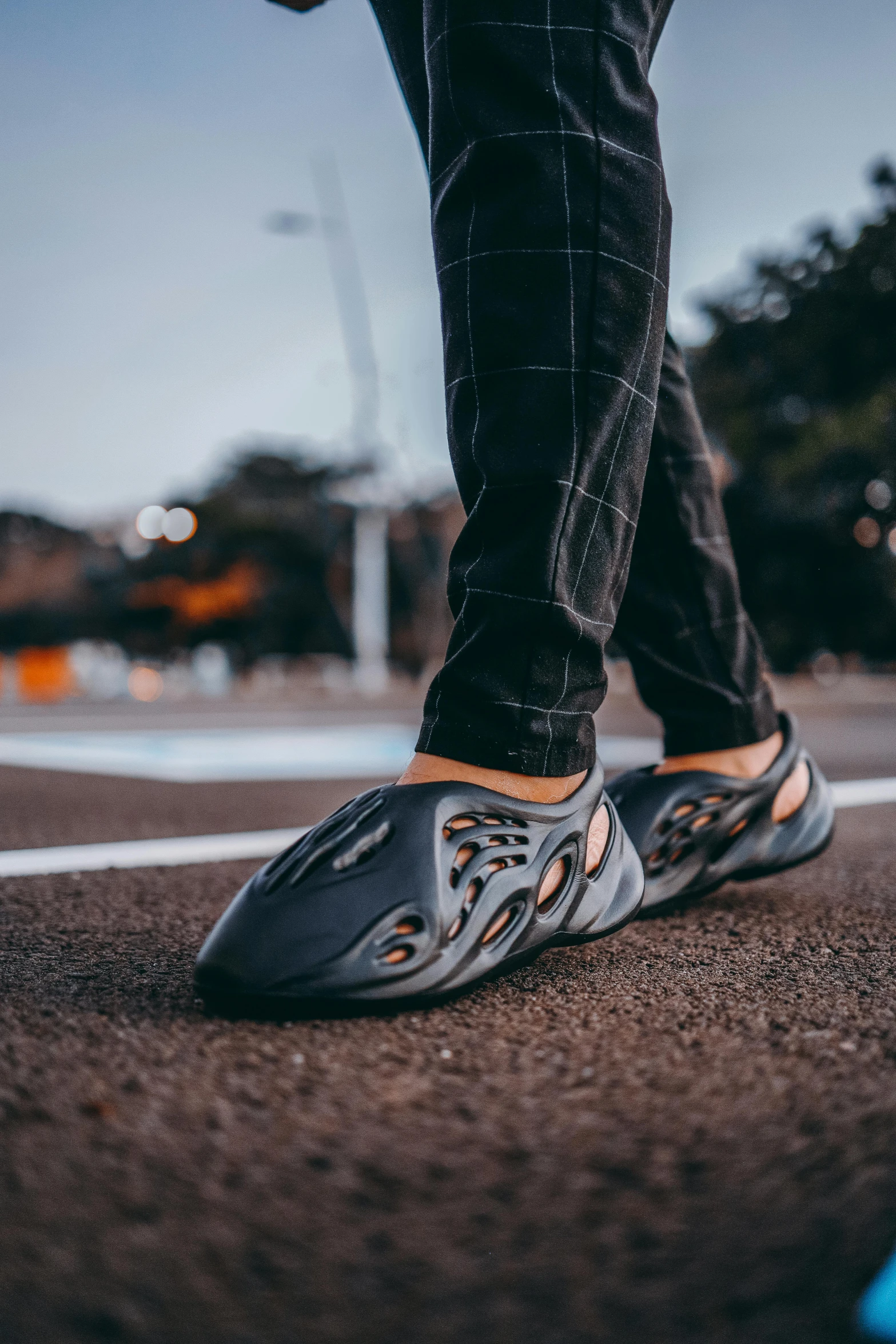 a person stands on the pavement with shoes