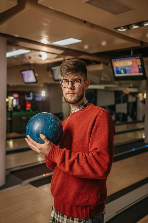 a man in glasses holding a bowling ball