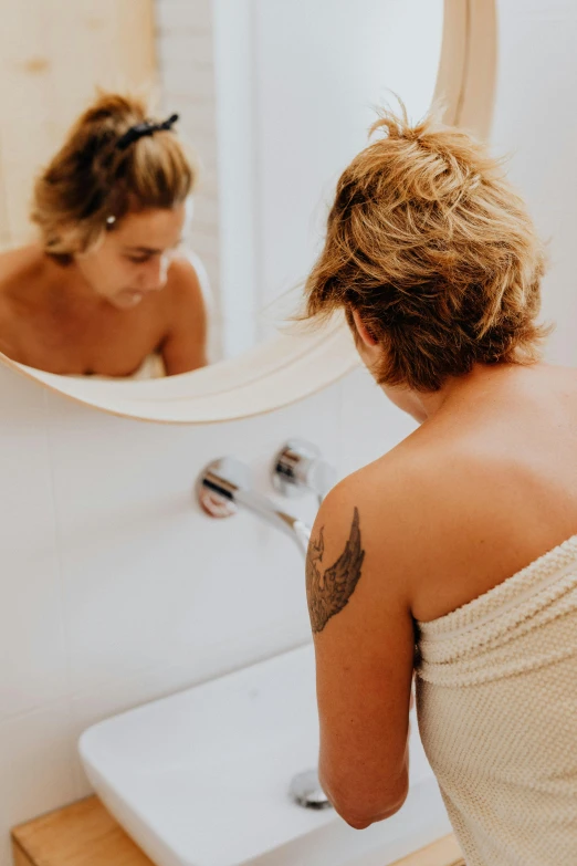 a young woman looking at her reflection in the mirror