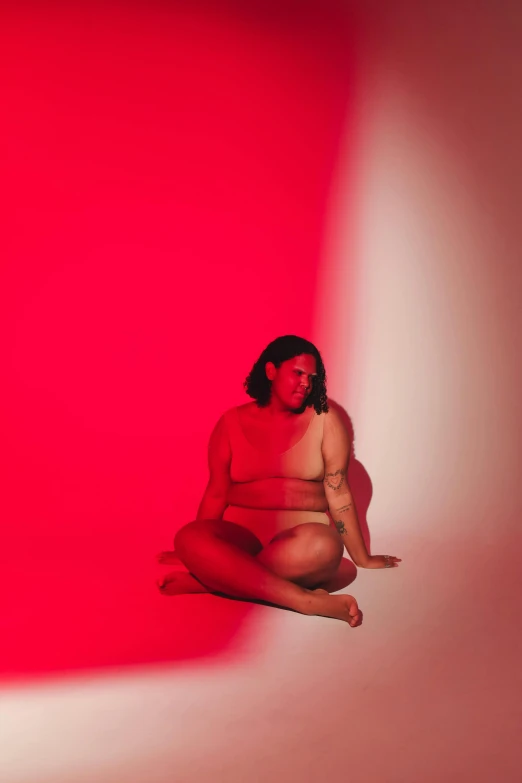 a woman is sitting in a pink room and poses