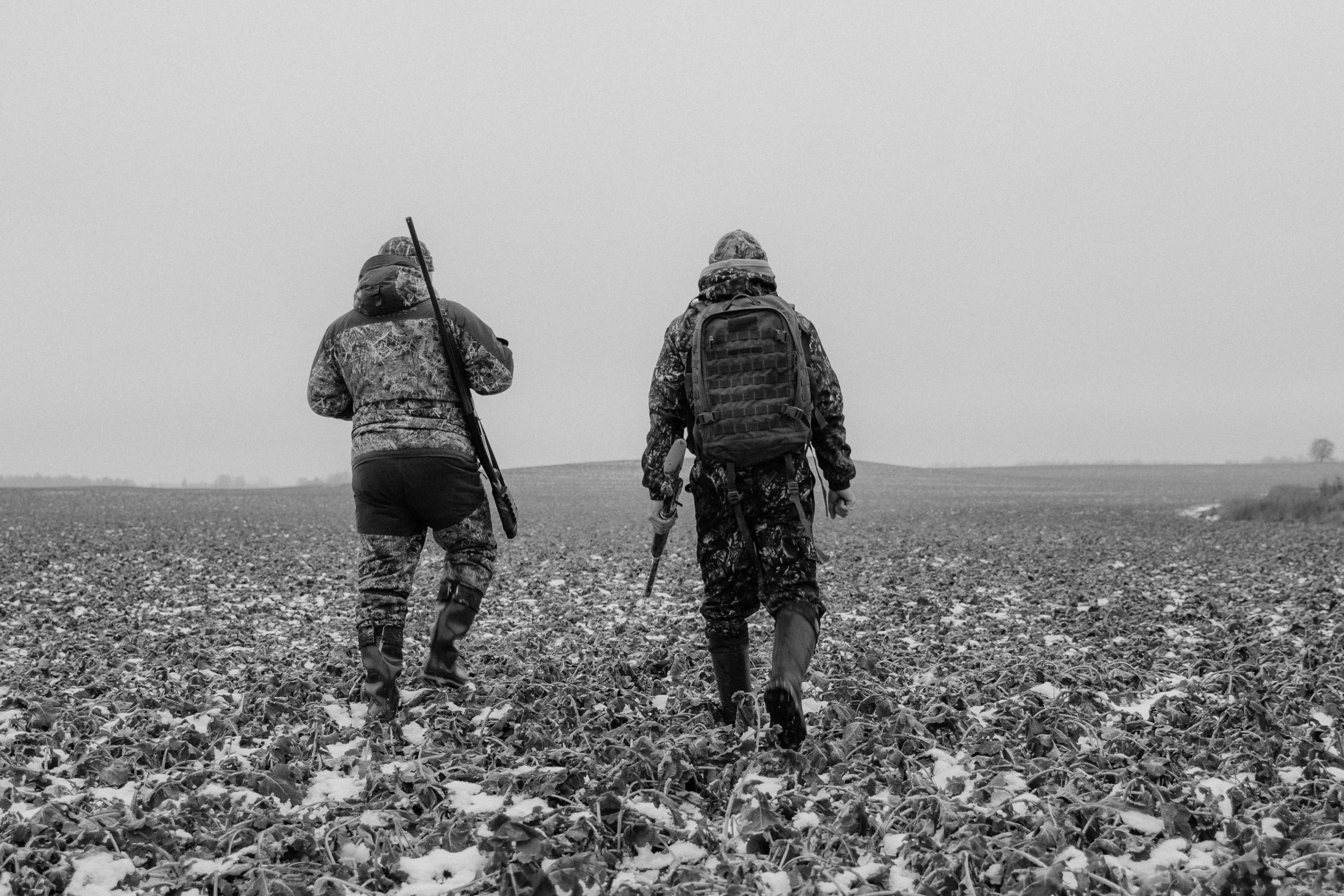 a couple of people walking through a field