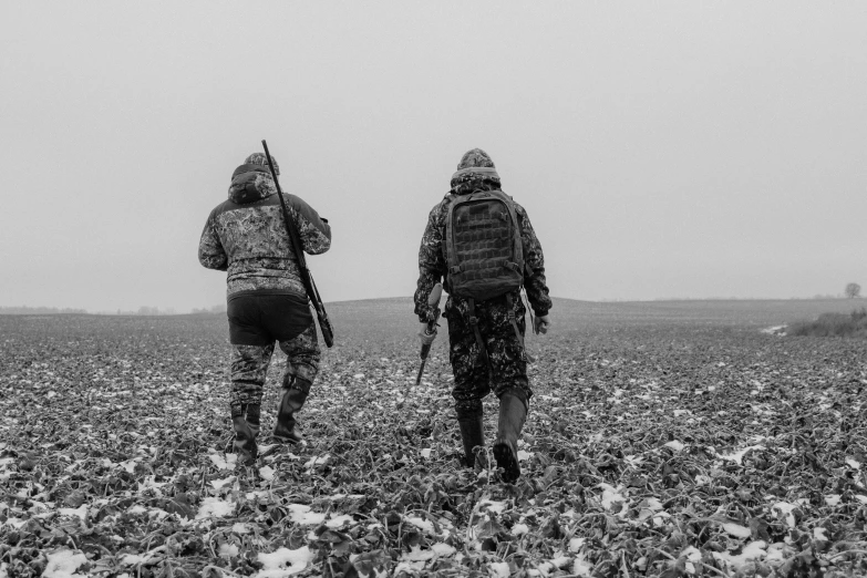 a couple of people walking through a field