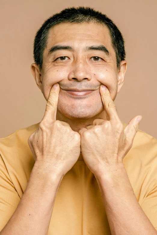 man showing his smile while covering his face