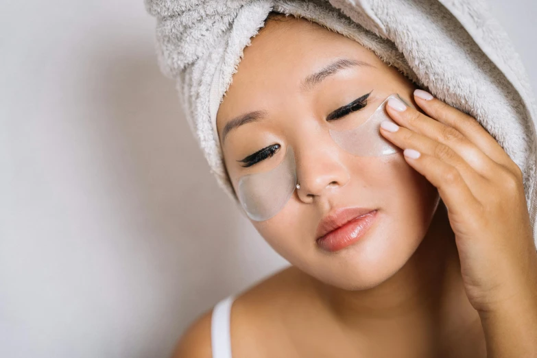 a woman in white towel with face mask on