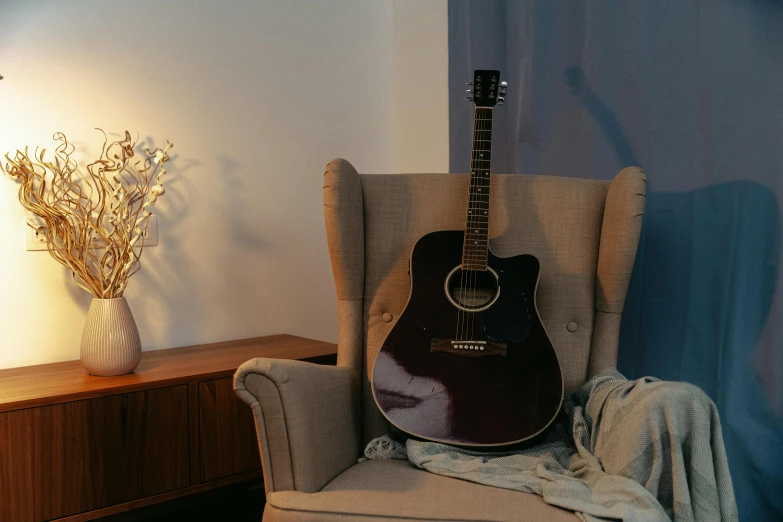 a small guitar sitting in an empty chair