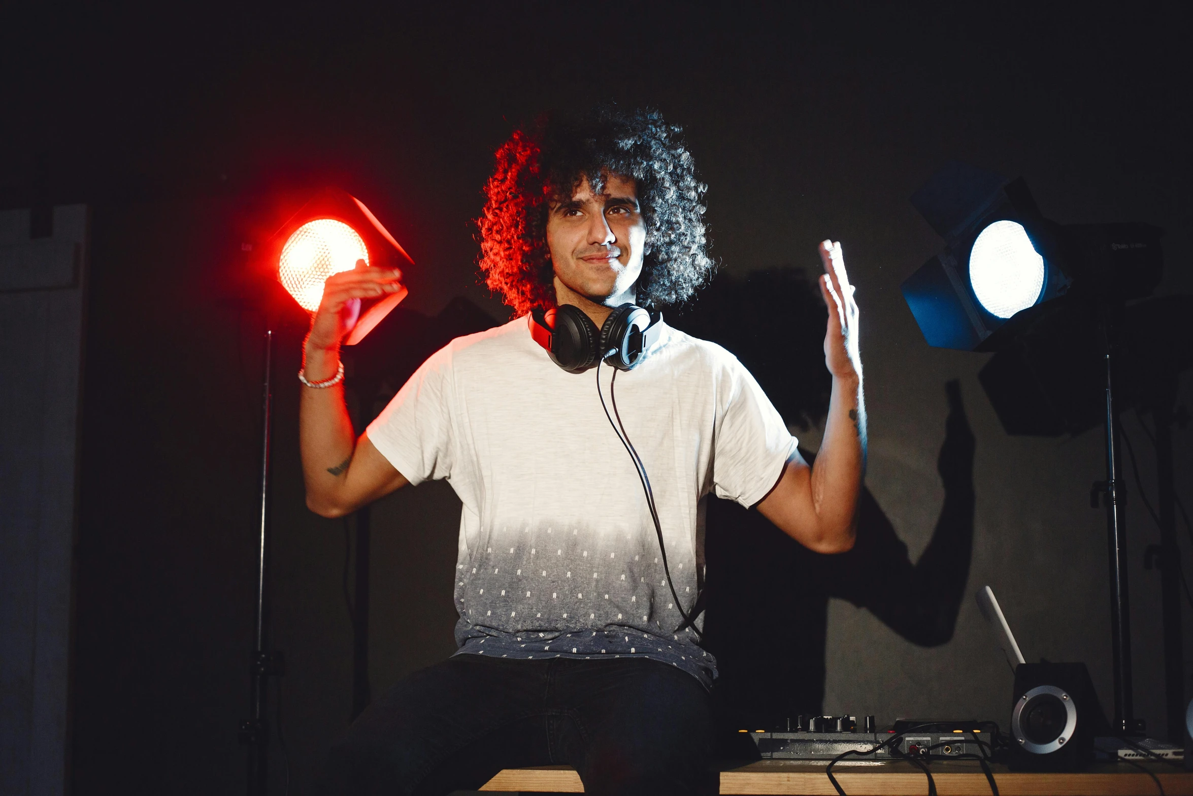 a man with long hair is standing with one hand in the air