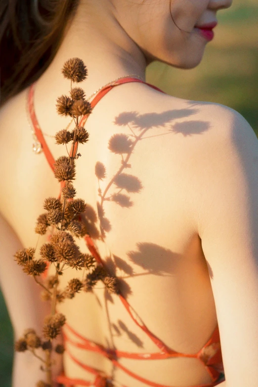 a girl has her back to the camera with the same flower tattooed