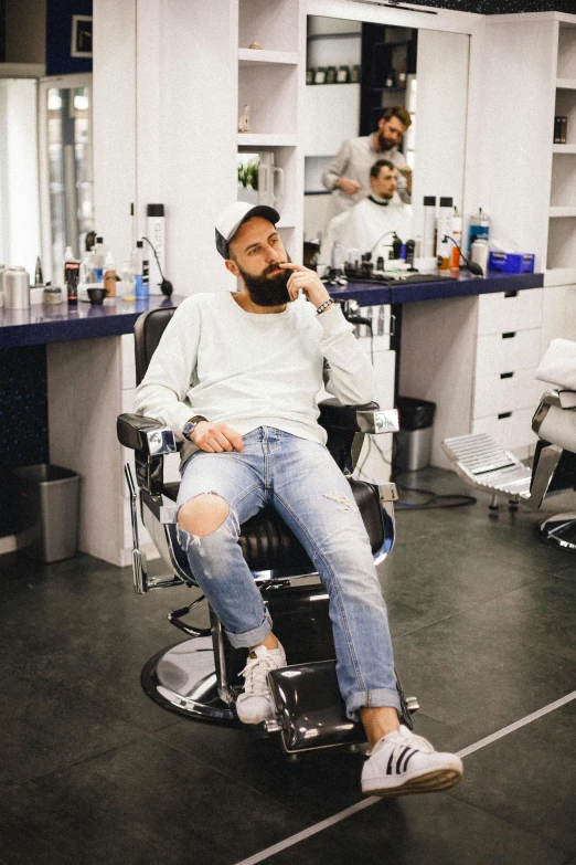 a person sitting in a barbershop and a mirror