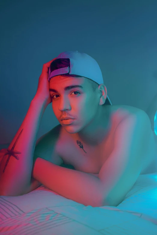 young male laying  wearing hat and blue and red light