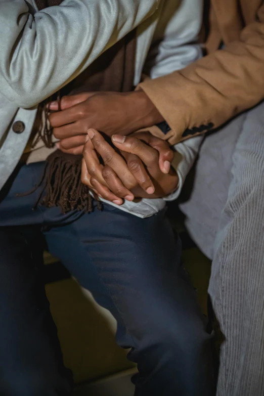 a group of people are clasped hands on their lap