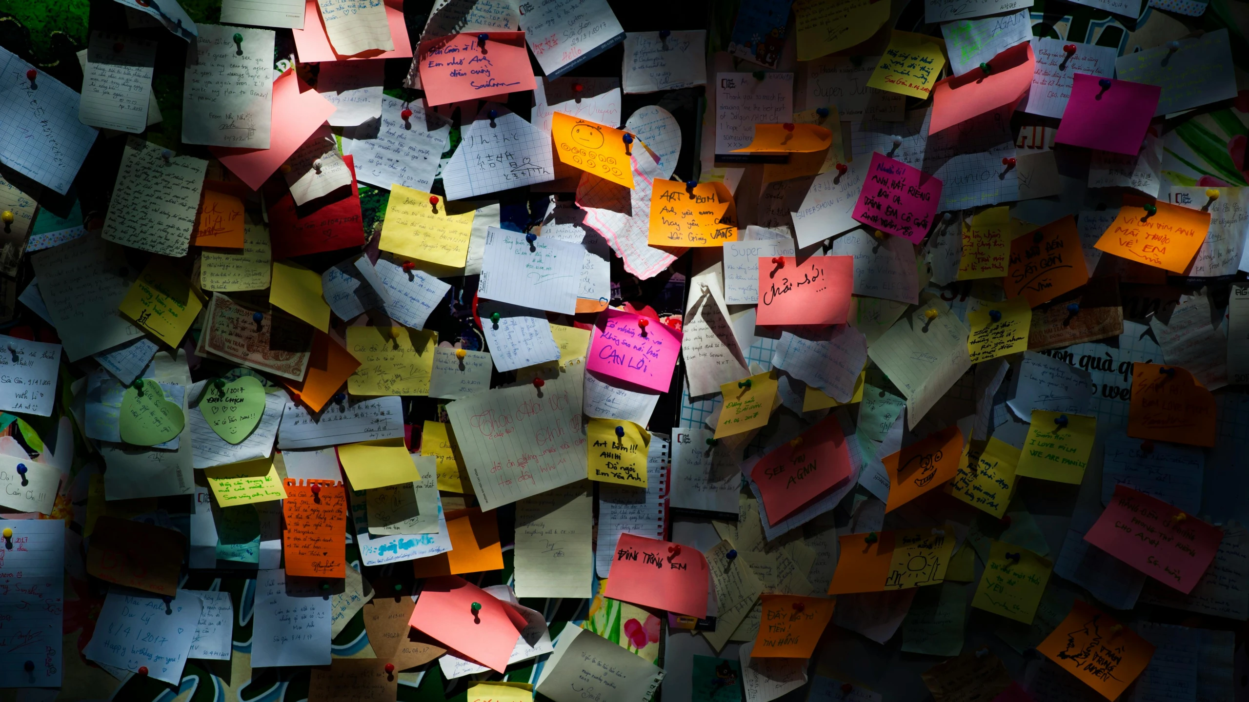 a wall with a large amount of papers written all over it