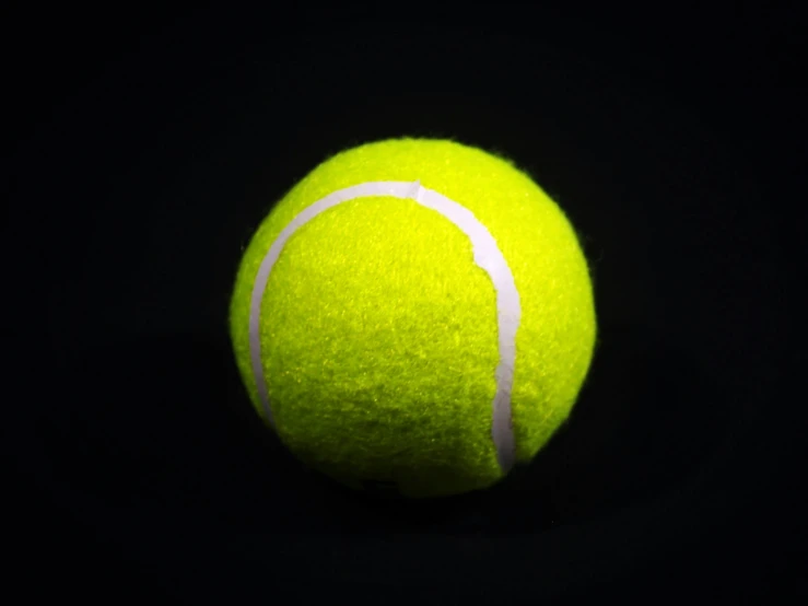 a closeup view of a tennis ball on a black background