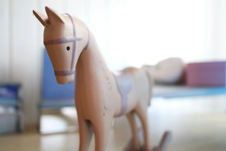 an adorable toy pony standing on a wood floor