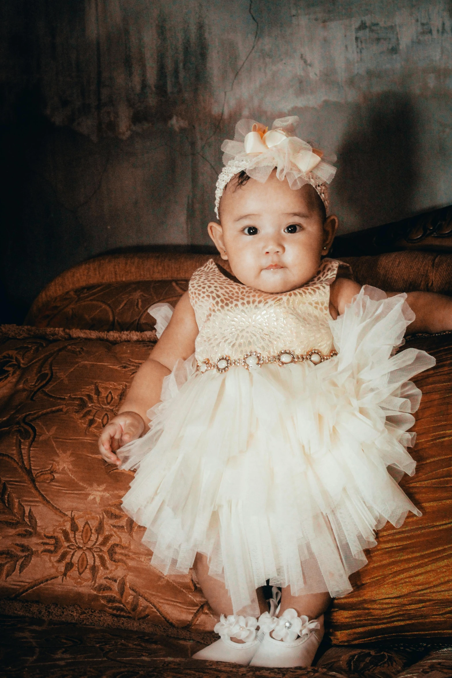 the small child is wearing a white tutu and flower headband