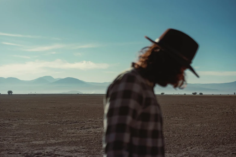 a man in plaid shirt looking at an open field