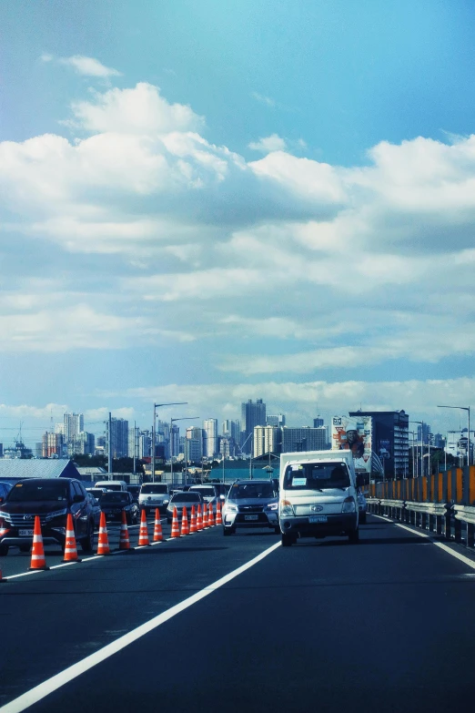 a city street filled with traffic and orange cones